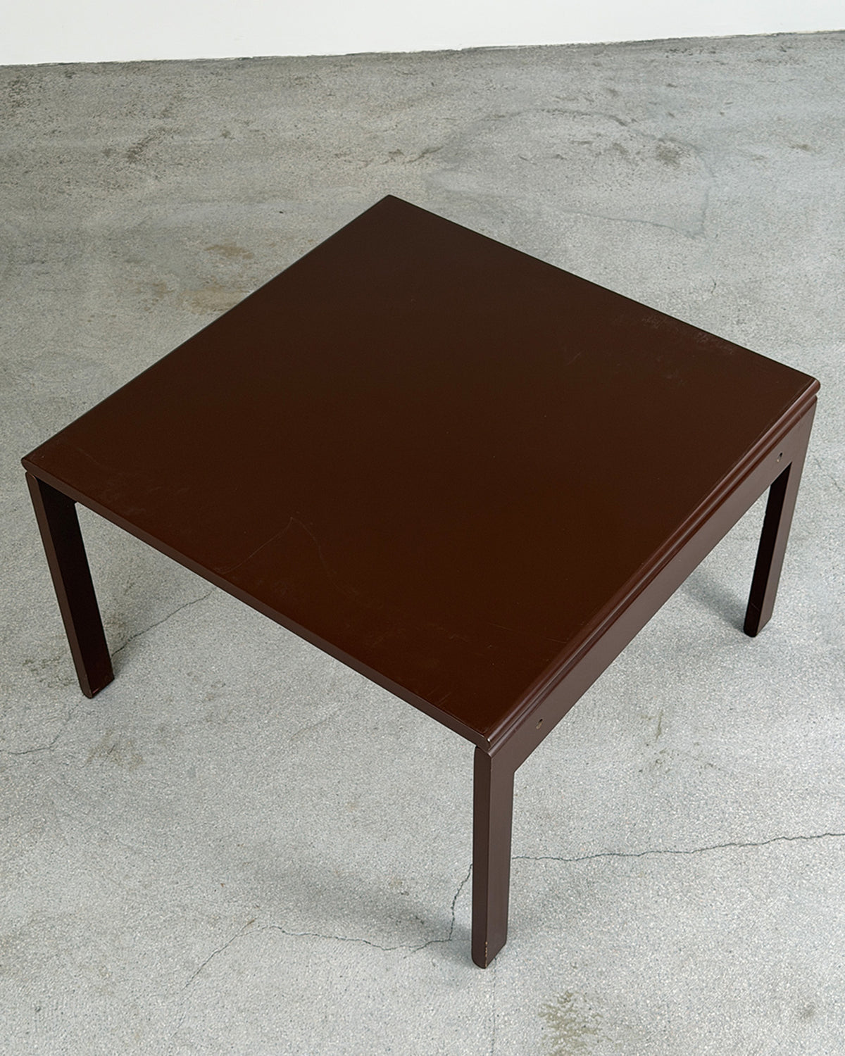 Brown square table on a concrete floor